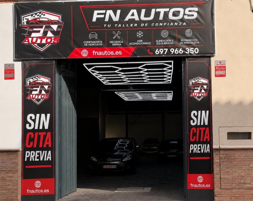 Entrada del taller FN AUTOS en Carrer del Santíssim Crist, Almazora — fachada con rótulos SIN CITA PREVIA y servicios de mecánica y compraventa